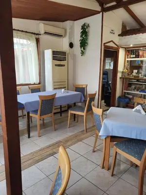 a dining room with tables and chairs and a kitchen at Solar in Plovdiv