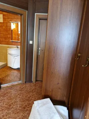 a bathroom with a toilet and a wooden door at Хотел-ресторант Астория in Pazardzhik