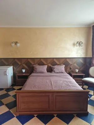 a bedroom with a large bed in a room at Хотел-ресторант Астория in Pazardzhik