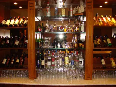 a bar with a lot of bottles of alcohol at Хотел-ресторант Астория in Pazardzhik