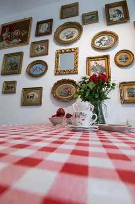 a red and white checkered table with a vase of flowers and pictures at SOTS apART in Sofia center in Sofia