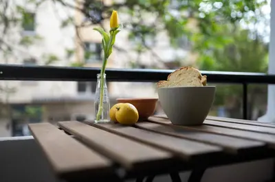 a table with a vase with a flower and a bowl of bread at SOTS apART in Sofia center in Sofia