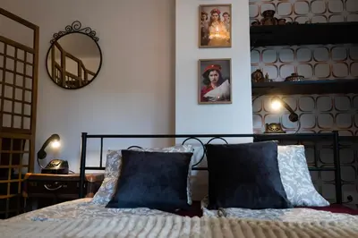 a bedroom with a bed with blue pillows and a mirror at SOTS apART in Sofia center in Sofia