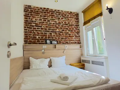 a bed in a room with a brick wall at Antim Boutique Apartments in Sofia
