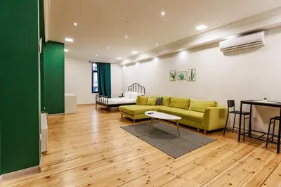 a living room with a green couch and a table at Saffron Guest House in Plovdiv