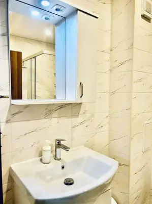 a bathroom with a white sink and a mirror at Malinova Stylish Apartment in Sofia