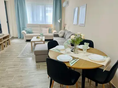 a living room with a table and a couch at Malinova Stylish Apartment in Sofia