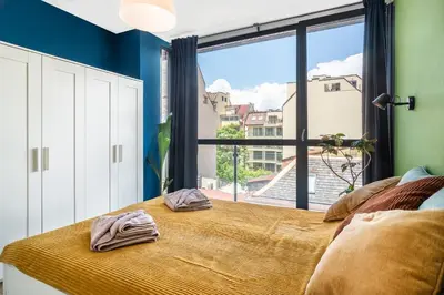 a bedroom with a bed with a large window at Artistic Flat in City Center for Business&Pleasure Trips in Sofia