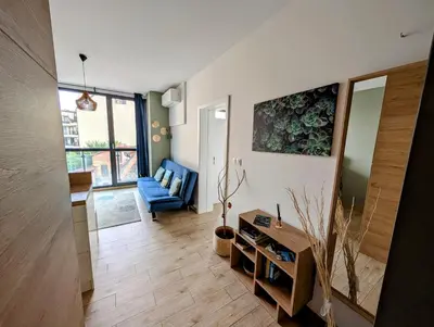 a living room with a blue couch and a table at Artistic Flat in City Center for Business&Pleasure Trips in Sofia
