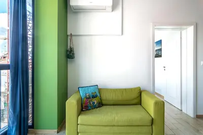 a living room with a green couch and a window at Artistic Flat in City Center for Business&Pleasure Trips in Sofia