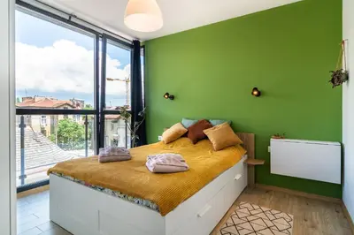 a bedroom with green walls and a large bed at Artistic Flat in City Center for Business&Pleasure Trips in Sofia