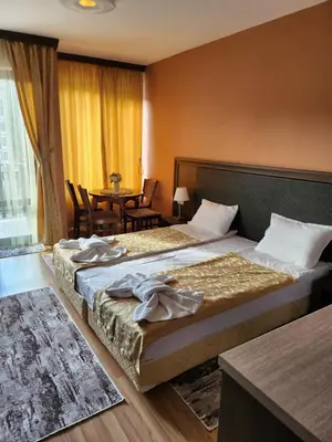 a hotel room with two beds and a table at Студио Бети Балнео Спа Хотел Свети Спас in Velingrad