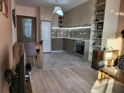 a large kitchen with a table and a refrigerator at Stylish apartment near City, entire flat, 1 bedroom, 1 large bed in living room in Plovdiv