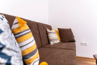 a couch with pillows on it in a living room at City Center Retro Chic Kapana 2-Bed Apartment in Plovdiv