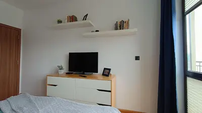 a bedroom with a tv on a dresser with a bed at Modern Comfort near Airport, The Mall, TechPark by KeyBox in Sofia
