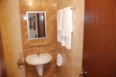a bathroom with a sink and a mirror at Едноспален апартамент Pirin Palace in Bansko