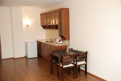 a kitchen with a table and chairs in a room at Едноспален апартамент Pirin Palace in Bansko