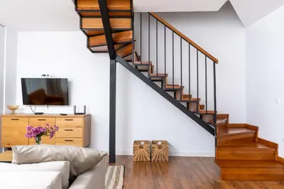 a living room with a couch and a staircase at Apart house EMA 4 in Bansko
