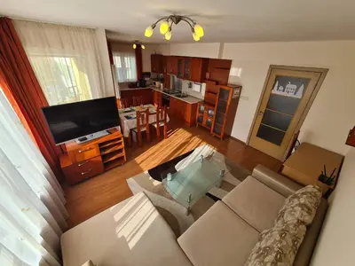 a living room with a couch and a tv and a kitchen at Spacious 2 Bedroom Apartment in Sofia