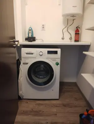 a washing machine in a small room with a shelf at Happy Apartment & Free Breakfast - Mladost in Sofia