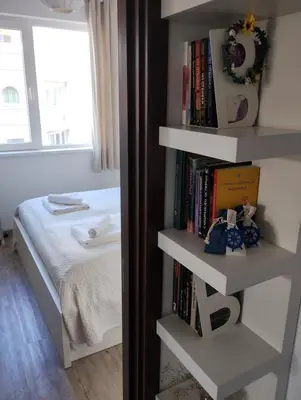 a bedroom with a book shelf next to a bed at Happy Apartment & Free Breakfast - Mladost in Sofia