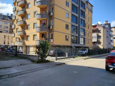 a yellow building with cars parked in front of it at Happy Apartment & Free Breakfast - Mladost in Sofia