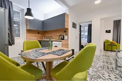 a kitchen with a table and green chairs at Apart Hotel Roma in Sofia