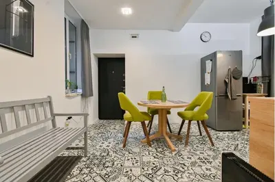 a dining room with a table and yellow chairs at Apart Hotel Roma in Sofia