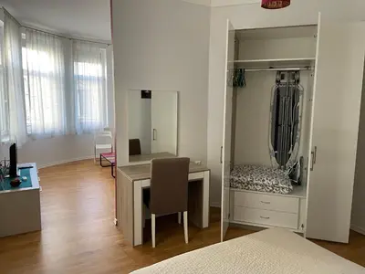 a bedroom with a desk and a bed and a mirror at The Central Post Apartments in Sofia