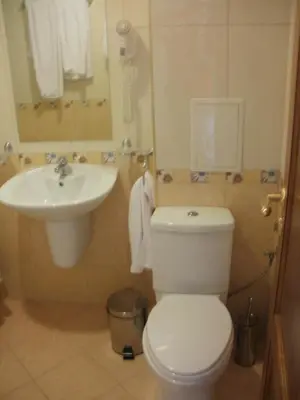 a bathroom with a white toilet and a sink at Deluxe Room in Stoykite in Pamporovo