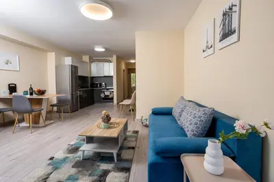 a living room with a blue couch and a table at Central & Quiet 2BR with Free Private Parking in Sofia