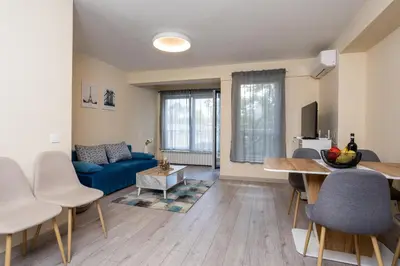 a living room with a blue couch and a table at Central & Quiet 2BR with Free Private Parking in Sofia