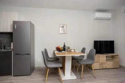 a kitchen with a table with chairs and a refrigerator at Modern 1BR Comfort in Oborishte with Private Parking in Sofia