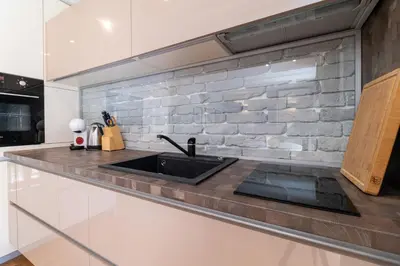 a kitchen with a sink and a brick wall at Central 1-bedroom Apartment in Plovdiv