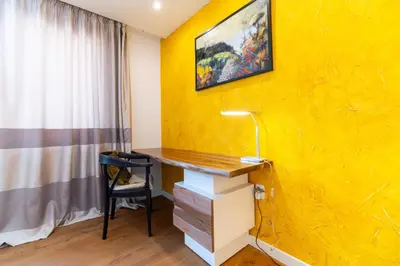 a yellow wall in a room with a desk and a chair at Central 1-bedroom Apartment in Plovdiv