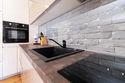 a kitchen with a sink and a brick wall at Central 1-bedroom Apartment in Plovdiv