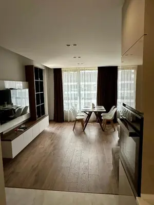 a kitchen with a table and chairs in a room at Apartment G17 in Pernik