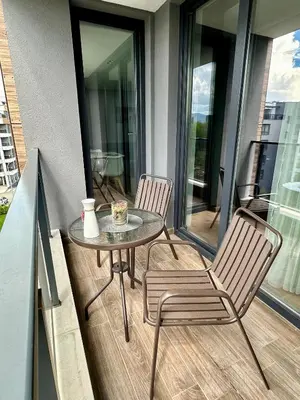 a table and two chairs on a balcony with a table at Apartment G17 in Pernik
