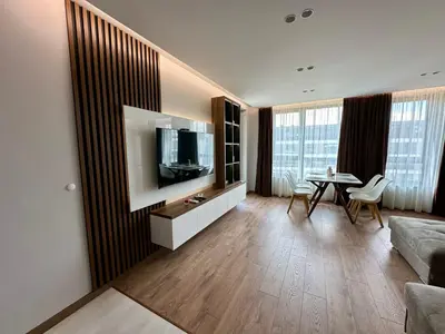 a living room with a television and a table at Apartment G17 in Pernik