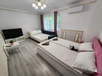 a bedroom with a large bed and a couch at luxury two bedroom Crown Apartament in Pravets