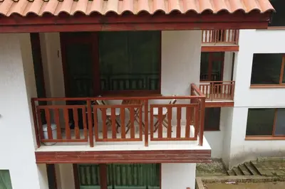 a wooden balcony of a building with a red roof at Apartment Atanasov - Pamporovo in Pamporovo