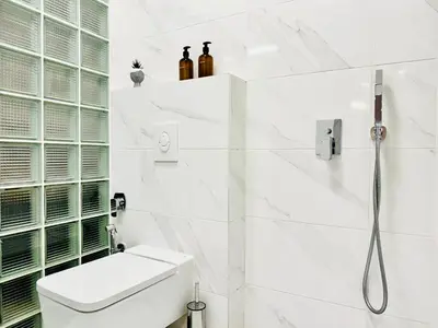 a white bathroom with a toilet and a shower at Cozy Apartment near Vitosha Blvd in Sofia