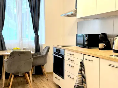 a kitchen with a table and a microwave at Cozy Apartment near Vitosha Blvd in Sofia