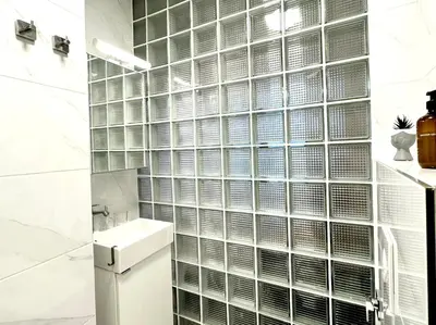 a bathroom with a wall of glass block windows at Cozy Apartment near Vitosha Blvd in Sofia
