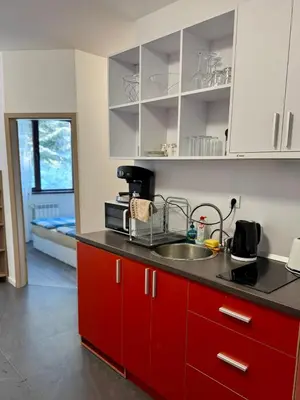 a kitchen with red cabinets and a sink at Sweet Apartment Flora Violet 3 in Borovets