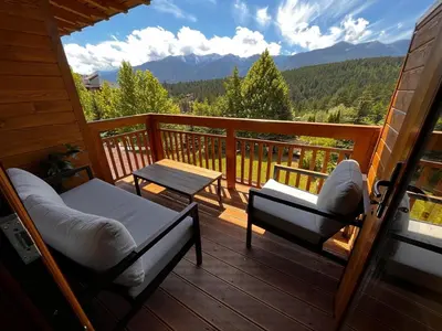 a porch with two chairs and a table on a deck at Vista Villa at Katarino SPA in Bansko