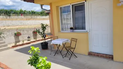 a patio with a table and chairs on a house at Strumyani tiny flat in Sandanski