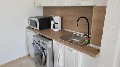 a small kitchen with a sink and a microwave at Strumyani tiny flat in Sandanski