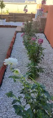 a garden with flowers and rocks and a fence at Strumyani tiny flat in Sandanski