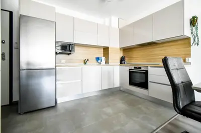 a kitchen with white cabinets and a stainless steel refrigerator at Nomad Friendly Modern Complex Next to Metro in Sofia